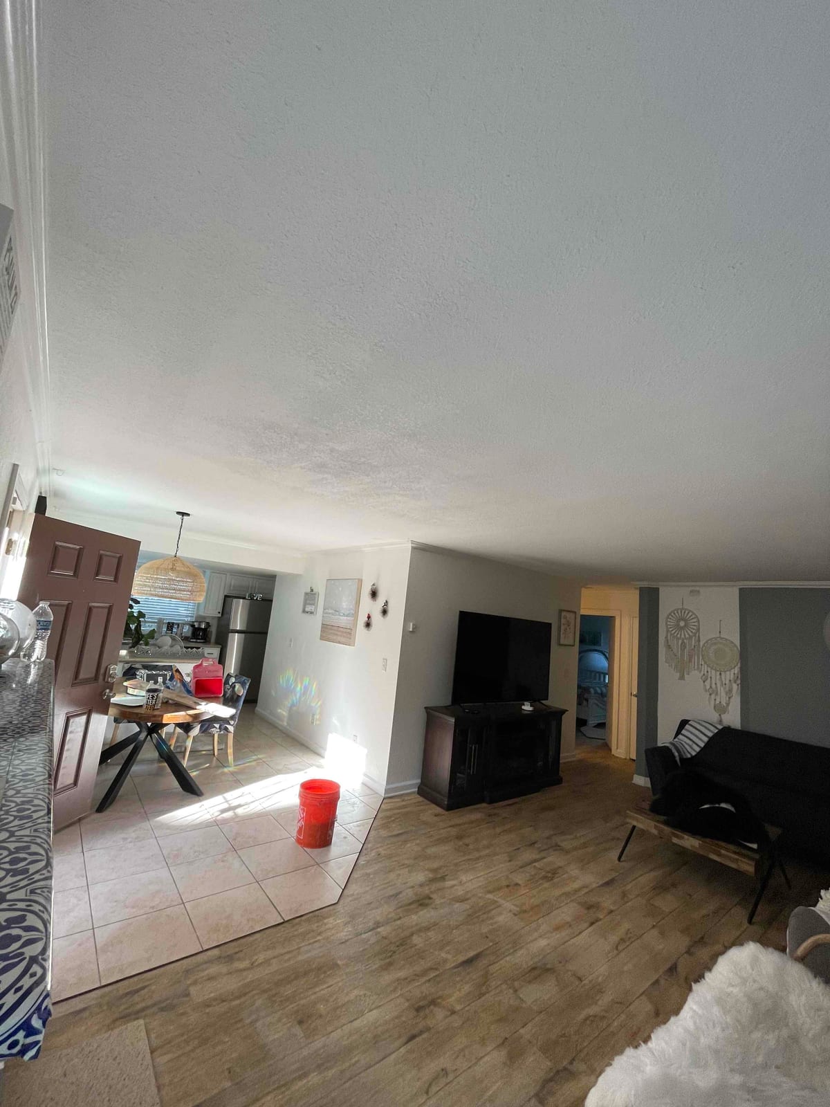 Repaired textured ceiling above an occupied living and kitchen area